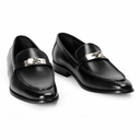 A pair of black leather penny loafers with a polished silver-tone metal bit detail across the vamp, displayed on a clean white background.