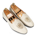 Pair of cream loafers with wooden insoles on a white background
