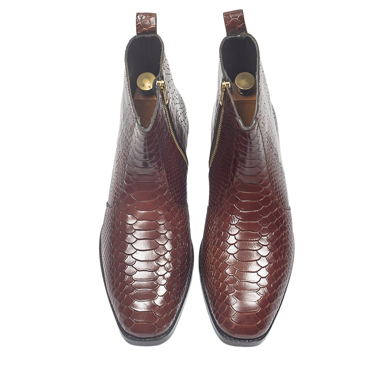 Brown textured ankle boots worn with rolled-up jeans on a neutral background