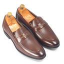 Pair of brown leather loafers with wooden insoles on a white background