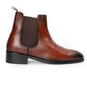 A brown leather Chelsea boot with a black block heel and elastic side gore, shown in a side profile on a white background.
