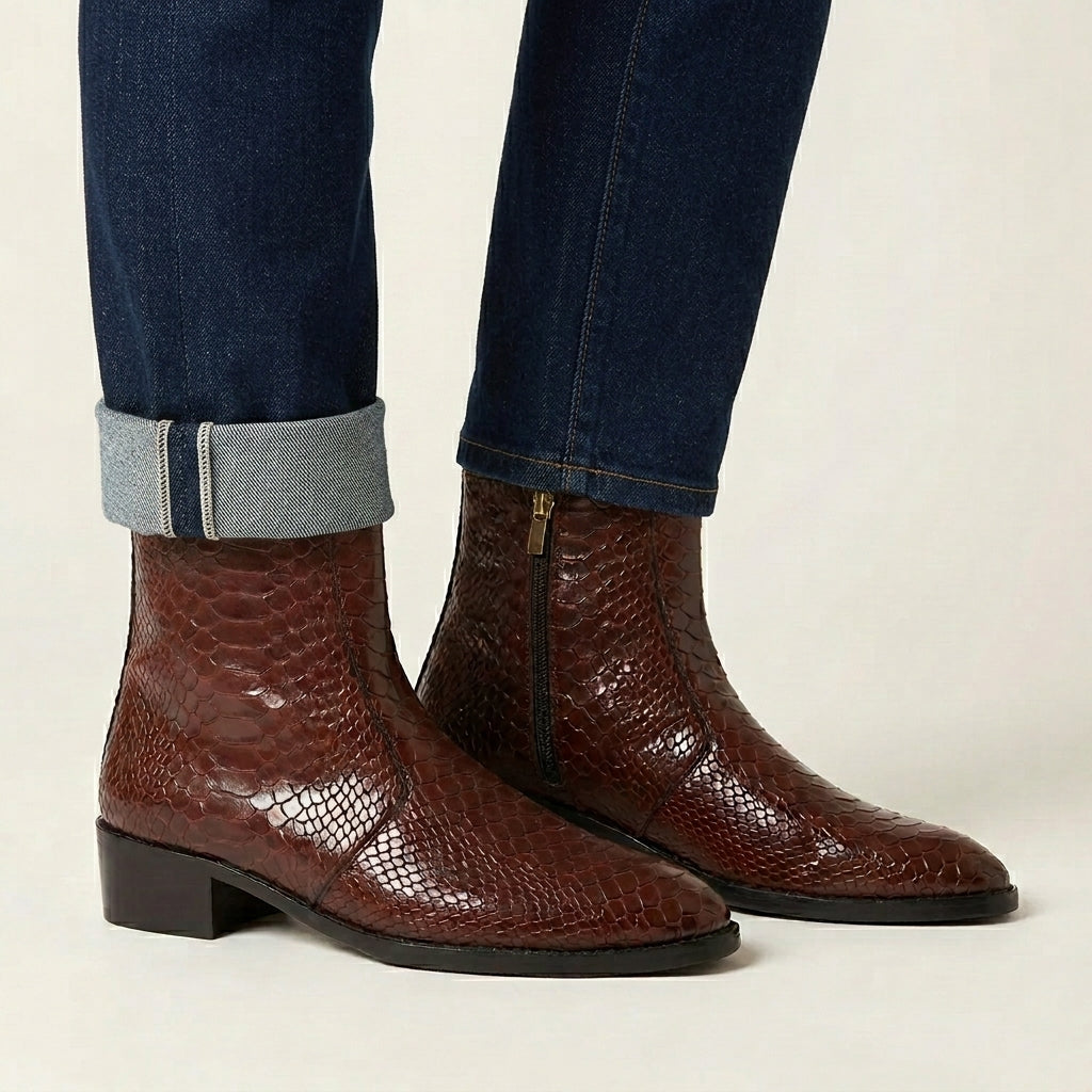 Brown textured ankle boots worn with rolled-up jeans on a neutral background