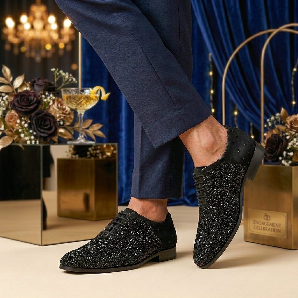 Black textured dress shoes worn with black pants on a light background