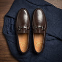 Pair of brown loafers on a dark blue fabric background