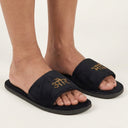 Black slides with gold embroidery on a white background
